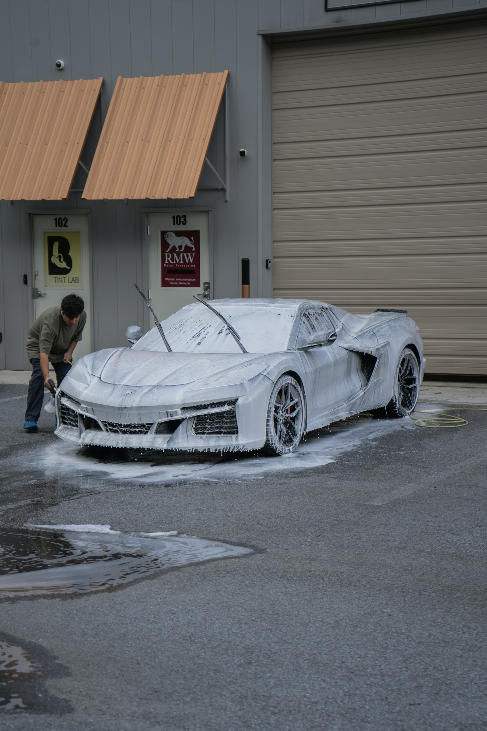 AQUAJET technician applying active foam to a car