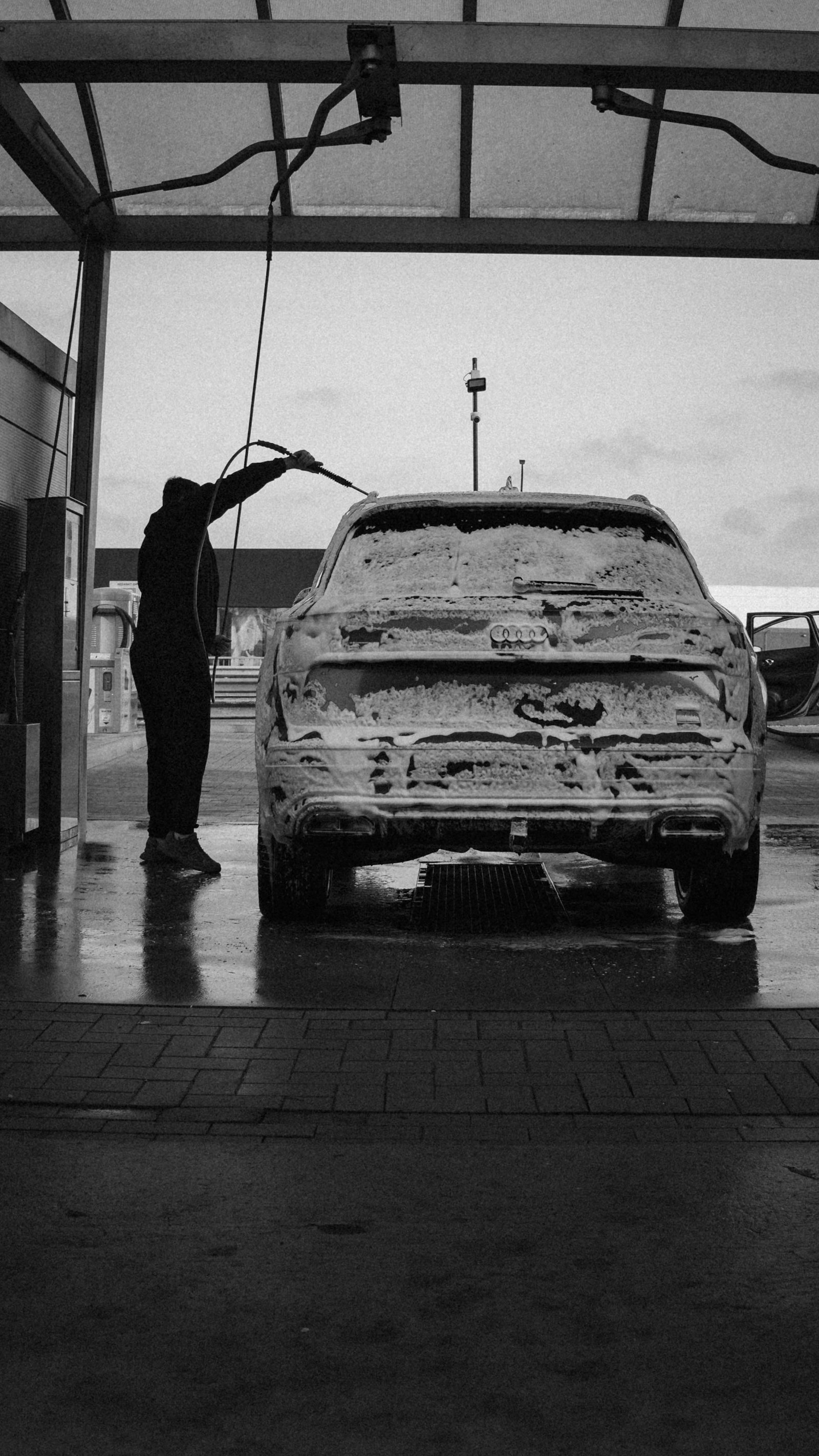 Car being washed with active foam under a canopy